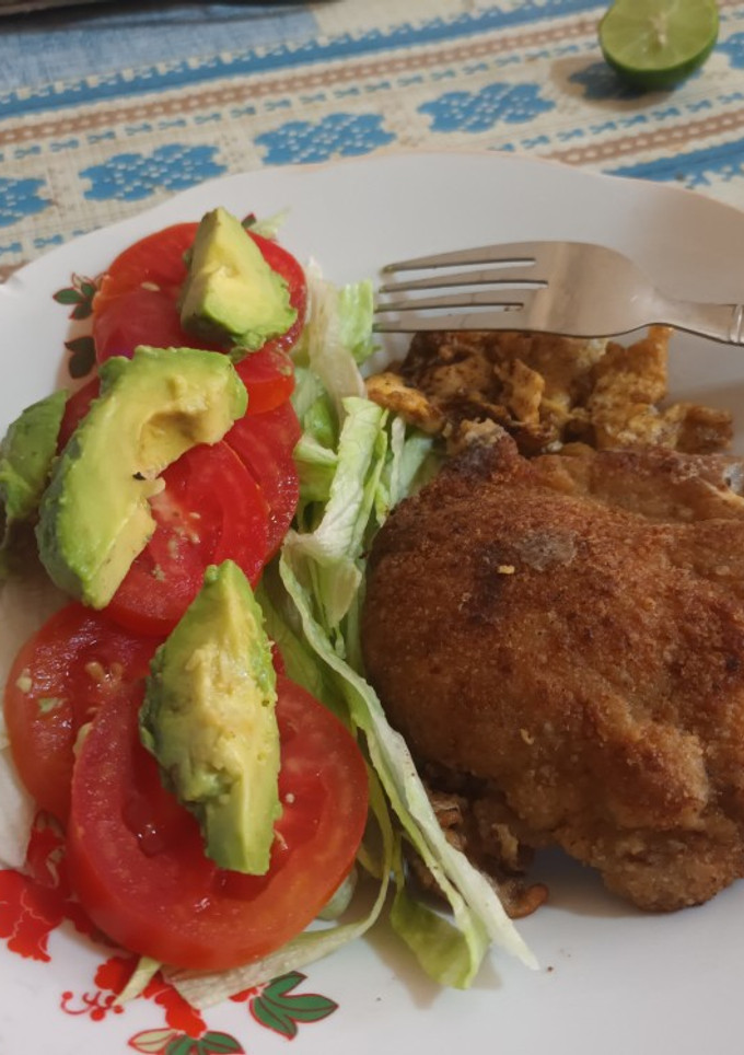 Una foto de Posta de cerdo empanizada con ensalada