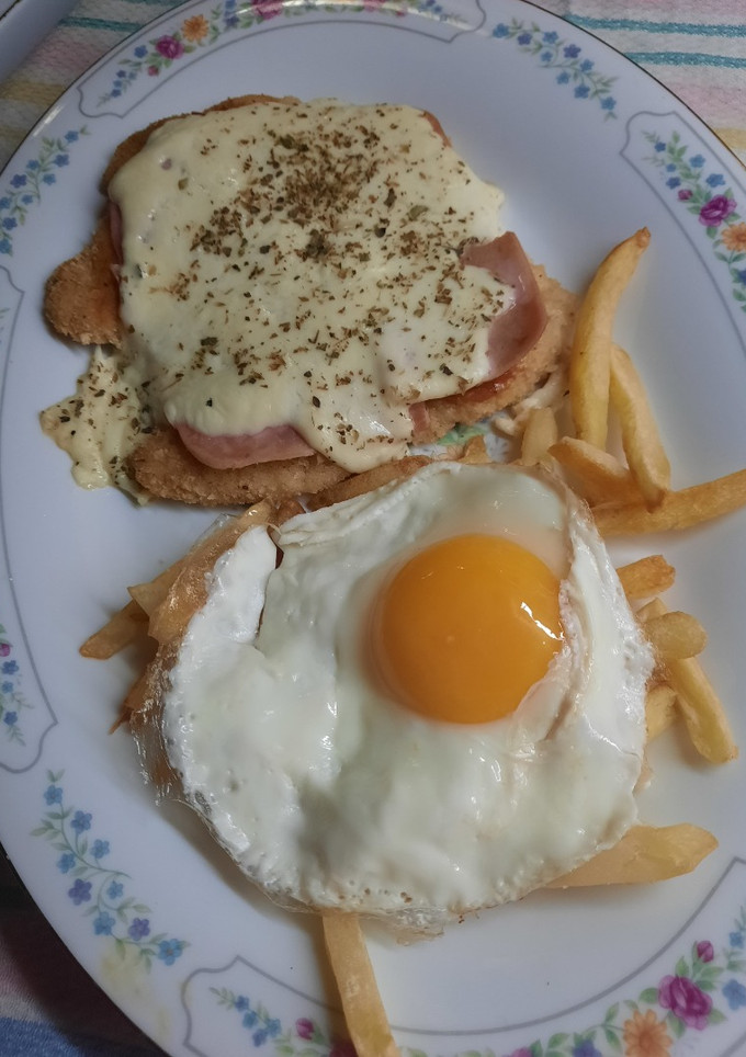 Una foto de Milanesa a la napolitana con papas fritas y huevo