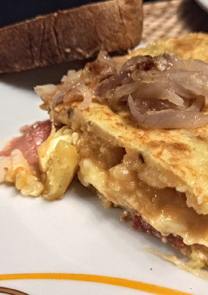 Una foto de Tortilla de patata con jamón y queso y cebolla caramelizada