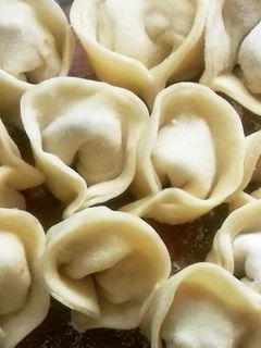 Una foto de Varenikes varios rellenos, con crema y salsa blanca