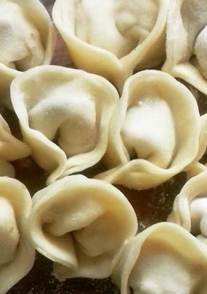 Una foto de Varenikes varios rellenos, con crema y salsa blanca