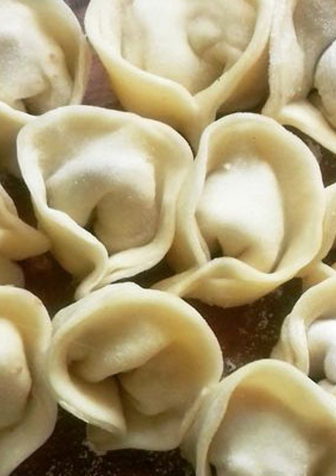 Una foto de Varenikes varios rellenos, con crema y salsa blanca