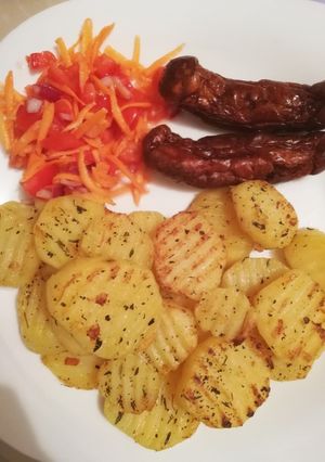 A picture of Seasoned potatoes, kachumbari & pork sausages.