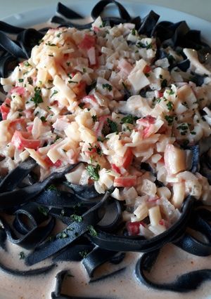 Una foto de Fideos Negros con salsa de Surimi
