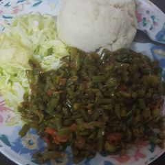 A picture of Ugali served with fried French beans and steamed cabbage.
