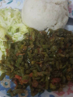 A picture of Ugali served with fried French beans and steamed cabbage.