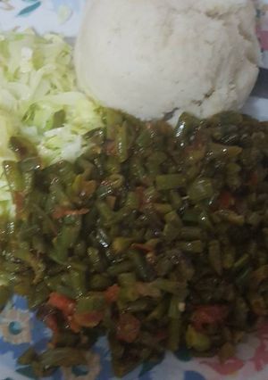 A picture of Ugali served with fried French beans and steamed cabbage.