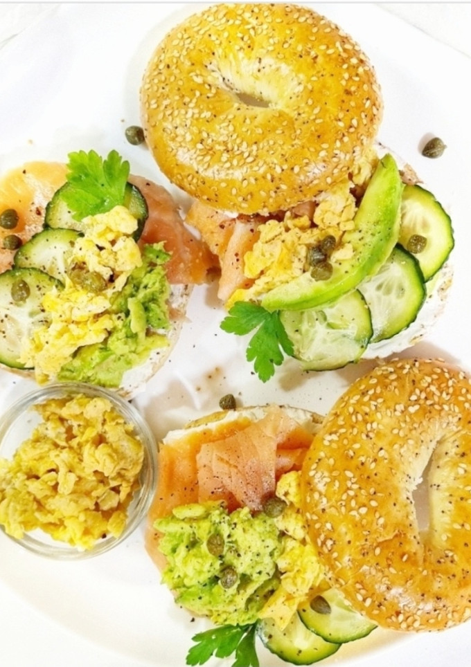 Una foto de Bagel relleno con salmón, huevos revueltos y aguacate