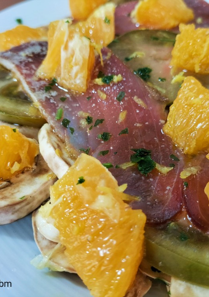 Una foto de Ensalada de tomate, champiñón y mojama con cítricos