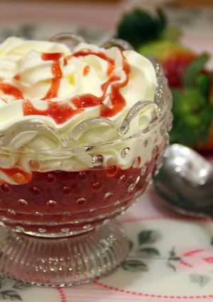 Una foto de Copa de fresas con frosting de queso y coulis de fresa