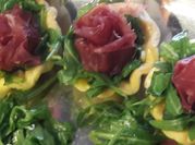 Una foto di rucola bresaola
