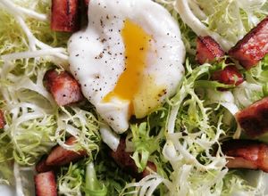 Una foto de Ensalada de lechuga frisée, tocino y huevo poché
