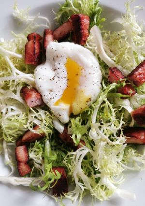 Una foto de Ensalada de lechuga frisée, tocino y huevo poché