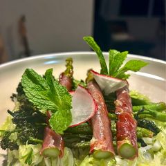A picture of Cabbage&fennel vinaigrette topped with spiced broccolini and prosciutto wrapped asparagus.