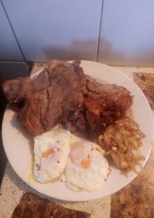 Una foto de Chuletas encebollada con huevos fritos