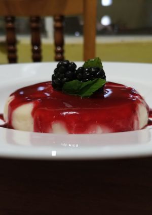 Una foto de Panna cotta de coco con coulis de zarzamora 🍽️