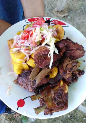 Una foto de Fritada de cerdo con ensalada CRIOLLA y patacones