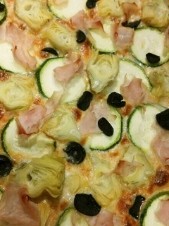 Una foto de Pizza de alcachofas, calabacín, jamón y aceitunas negras