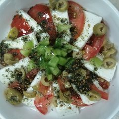 A picture of Haloumie cheese with tomato.