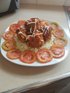Una foto de Empanizado de pollo en ensalada de col y tomates