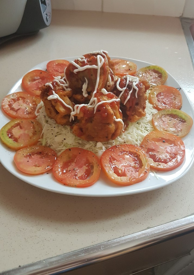 Una foto de Empanizado de pollo en ensalada de col y tomates