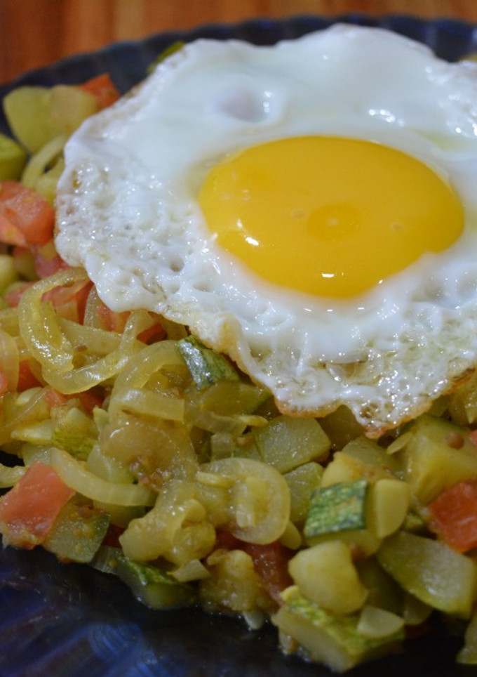 Una foto de Zucchini, tomate y huevo con un toque especiado