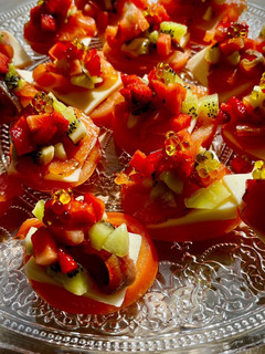 Una foto de Canapé de tomate con salmón marinado, kiwi y fresas