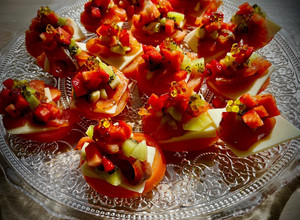 Una foto de Canapé de tomate con salmón marinado, kiwi y fresas