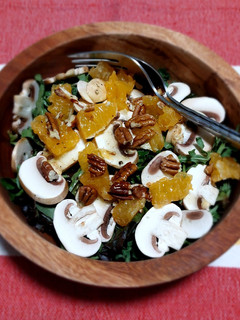 Una foto de Ensalada de hojas verdes con champiñones y mandarina