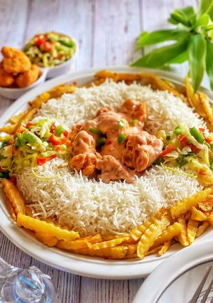 A picture of Saucy Crispy chicken with rice fries and vegetable.