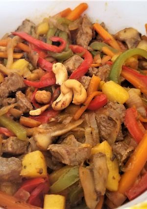 Una foto de Wok de carne con ananá y cilantro