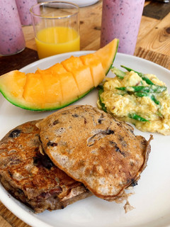 A picture of Banana pancakes with pecan nuts and fresh blueberries.
