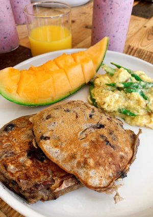 A picture of Banana pancakes with pecan nuts and fresh blueberries.