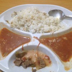 A picture of Fried rice served with beef stew.