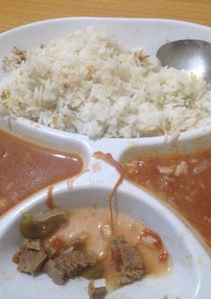A picture of Fried rice served with beef stew.