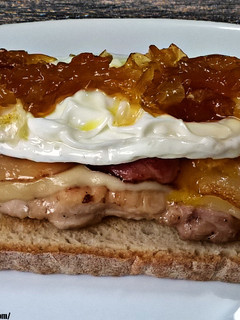 Una foto de Tosta de pollo con queso, bacon, huevo frito y cebolla caramelizada