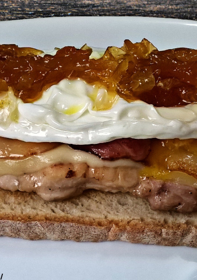 Una foto de Tosta de pollo con queso, bacon, huevo frito y cebolla caramelizada