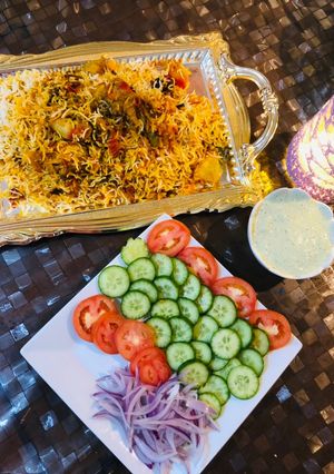 A picture of Biryani with colourful salad.