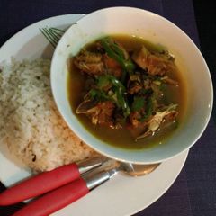 A picture of Ofada rice with chicken pepper soup.
