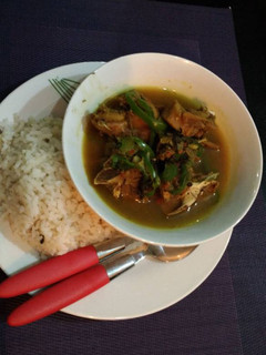 A picture of Ofada rice with chicken pepper soup.