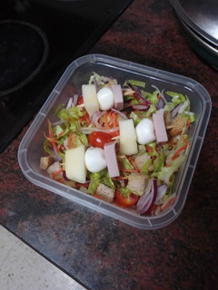 Una foto de Tupper de ensalada con banderilla de pavo, mozzarella y pera