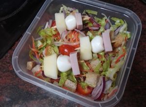 Una foto de Tupper de ensalada con banderilla de pavo, mozzarella y pera