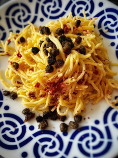 Una foto de Spaghetti picante con cremoso de tomate seco y alcaparras crujientes