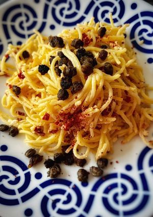 Una foto de Spaghetti picante con cremoso de tomate seco y alcaparras crujientes