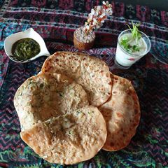 A picture of Potato paratha with mint chattny and cucumber raita.