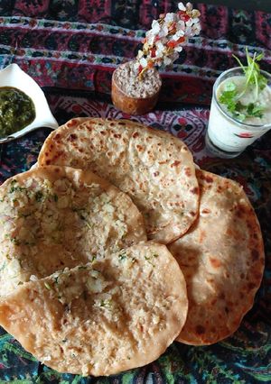 A picture of Potato paratha with mint chattny and cucumber raita.