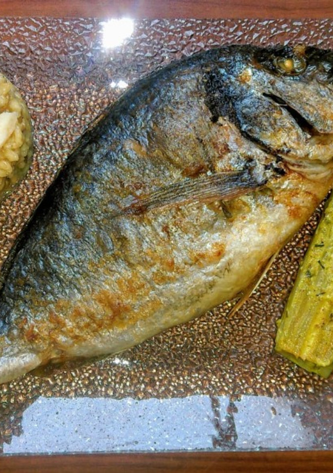 Una foto de Dorada al horno, risotto de champiñones y endivias en crema de cúrcuma
