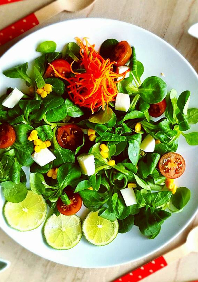 Una foto de Ensalada de canónigos aderezada con aceite de albahaca y lima
