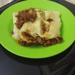 A picture of Lasagna rolls coated with cheese.