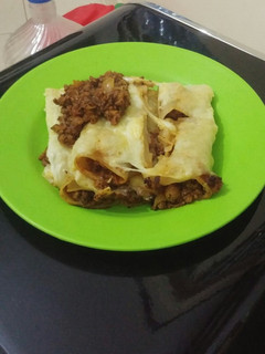 A picture of Lasagna rolls coated with cheese.